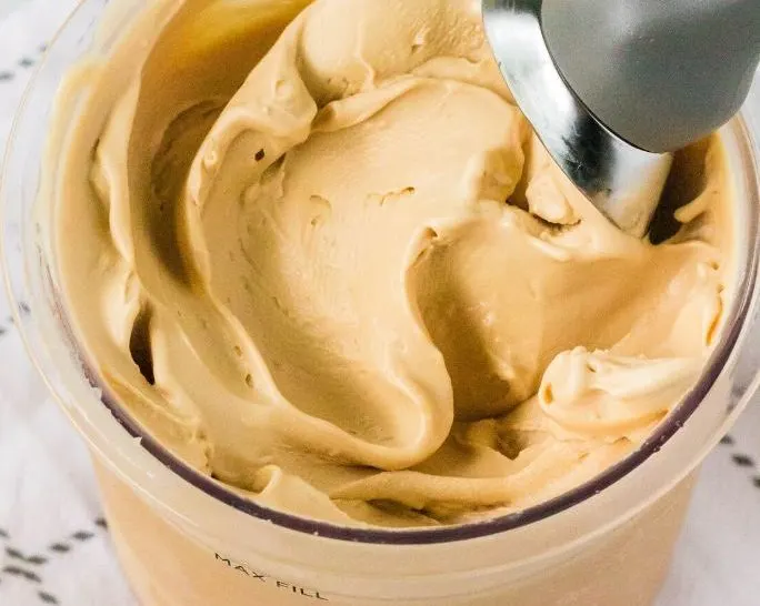 close-up view of a pint of ninja creami cookie butter ice cream with a scoop in it