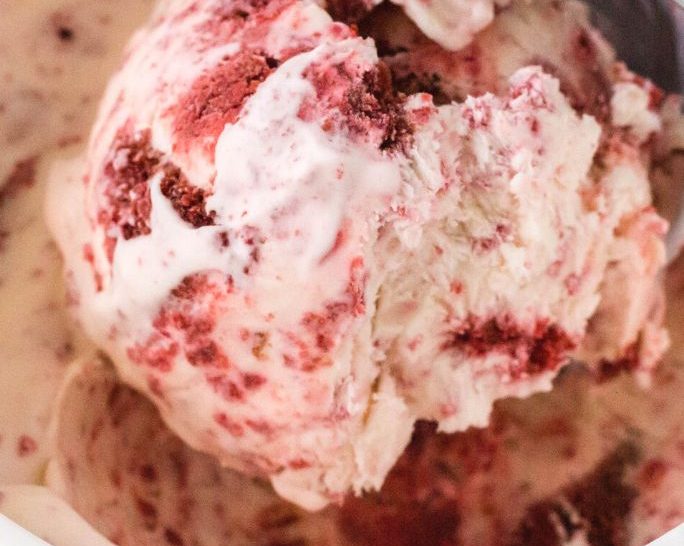 a scoop of homemade red velvet ice cream in a quart container