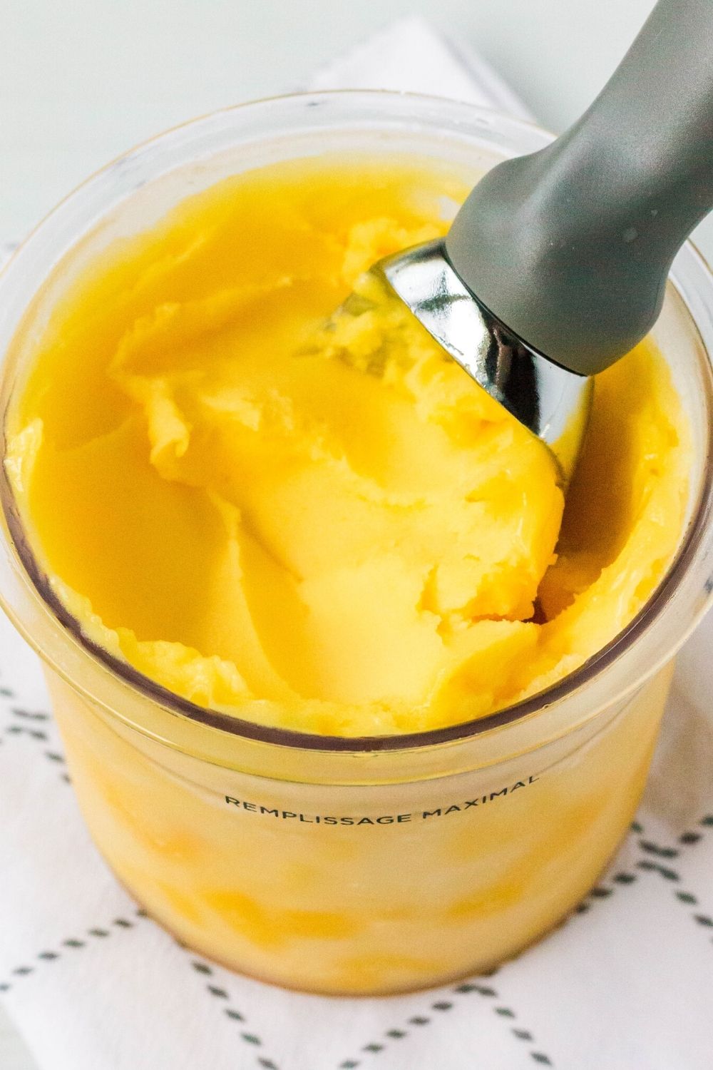 close-up view of a Ninja Creami pint filled with mango sorbet
