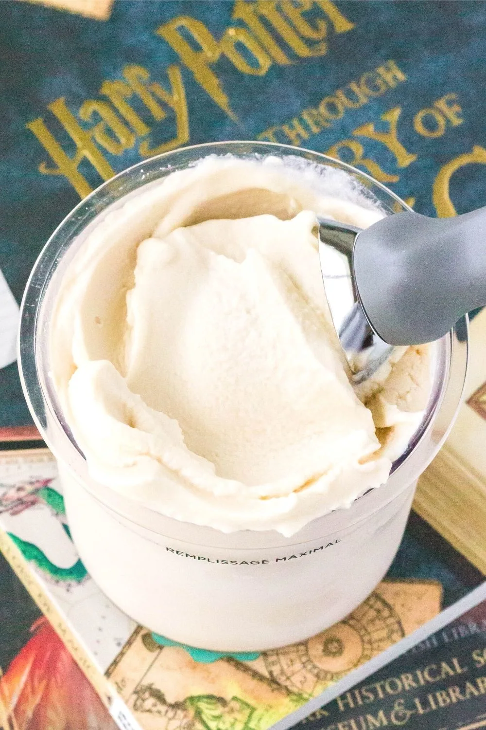 a Ninja Creami pint of butterbeer ice cream resting on a Harry Potter book