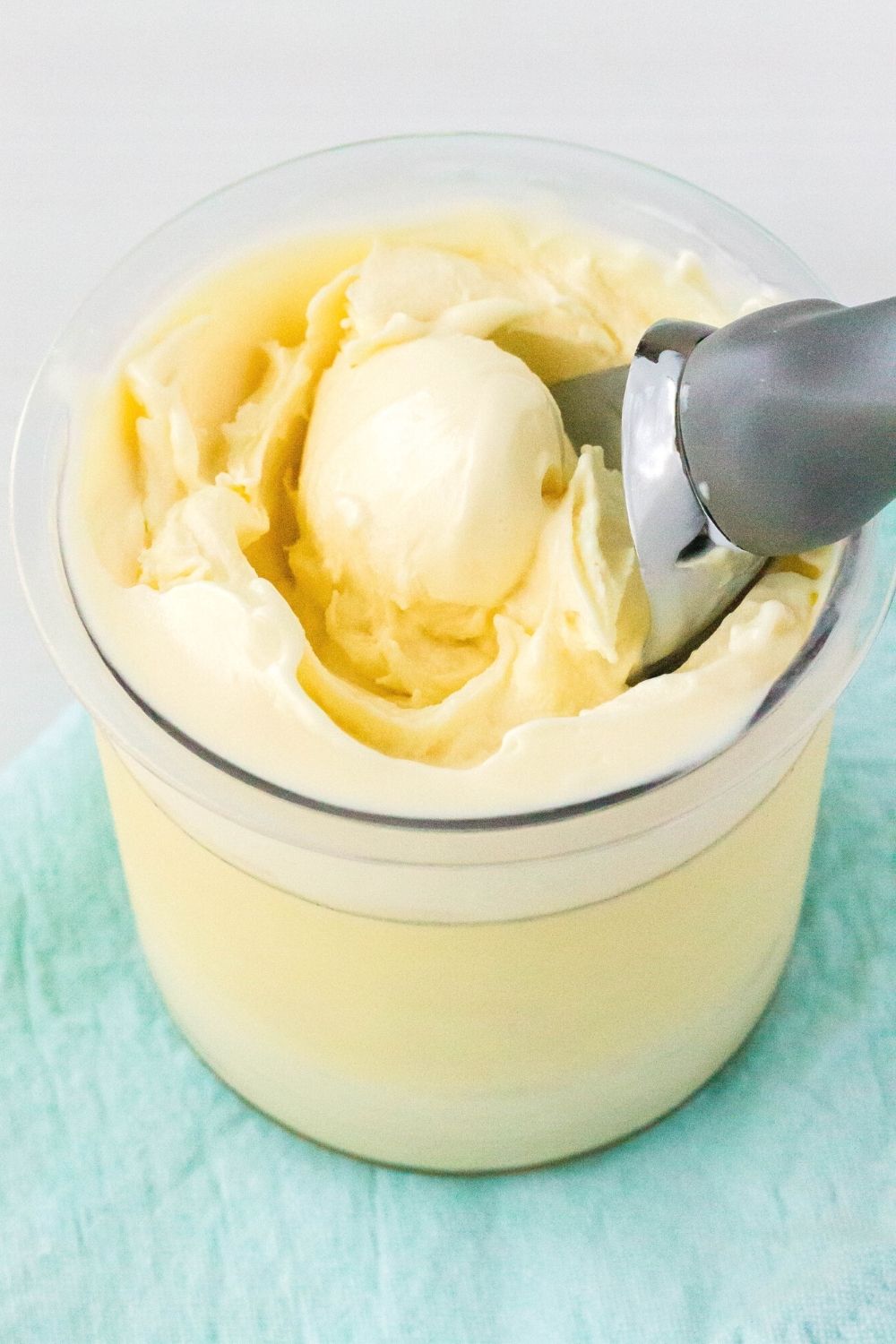 smooth and creamy Ninja Creami vanilla pudding ice cream in a pint container with an ice cream scoop