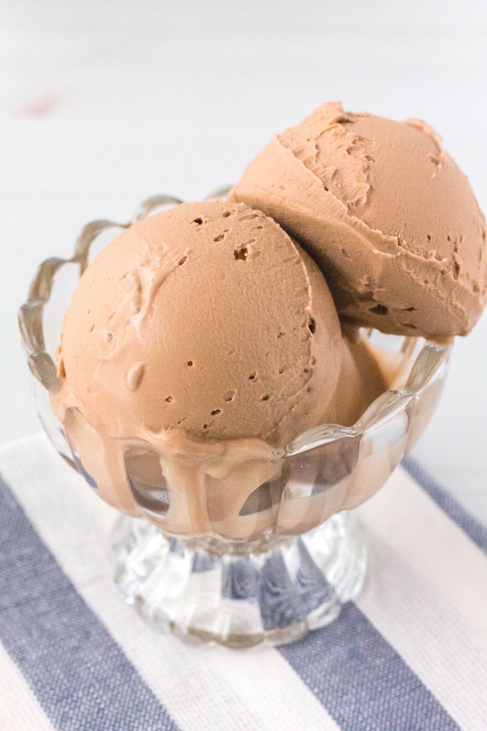 close-up side view of a glass dessert cup filled with scoops of ninja creami dairy free chocolate ice cream.