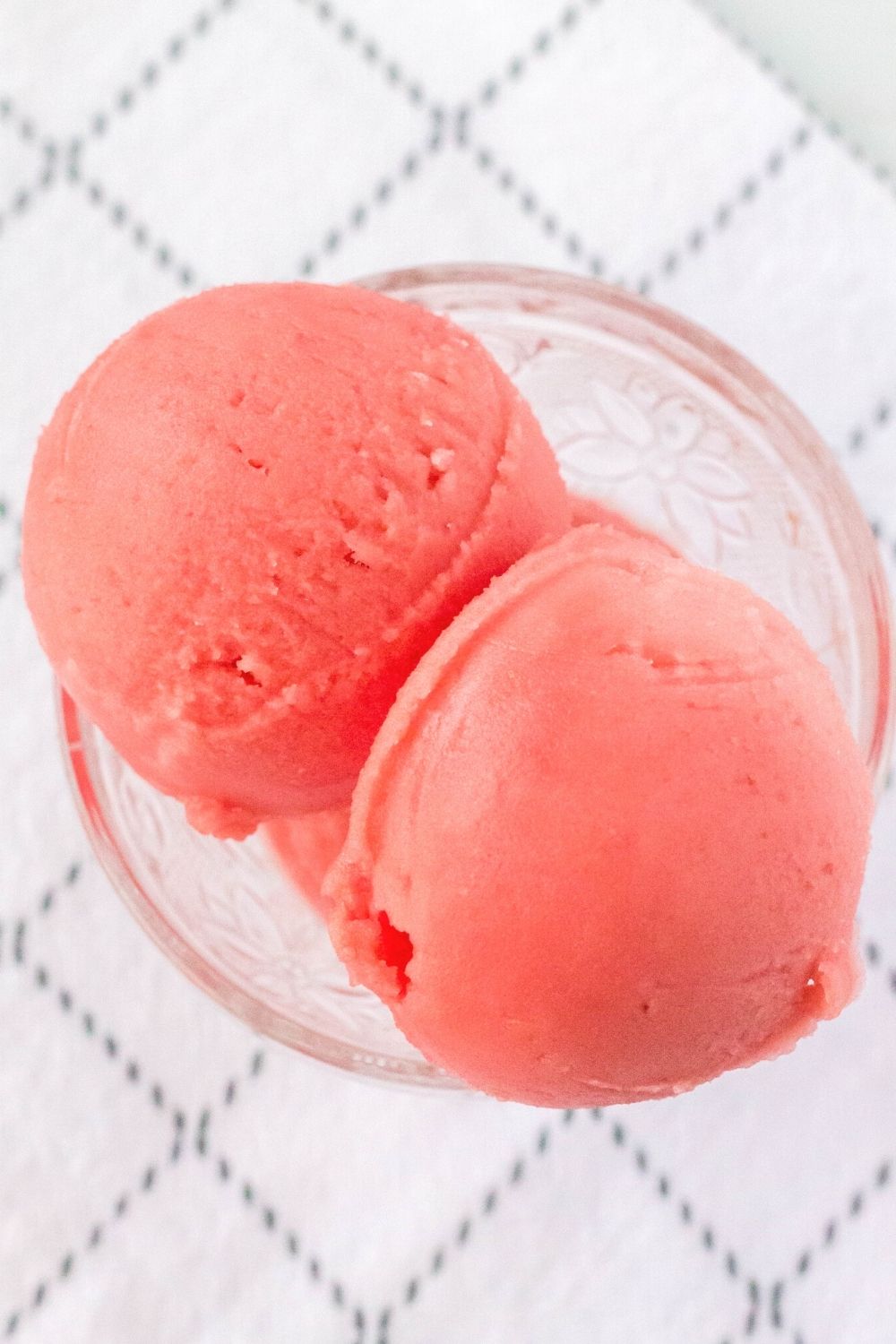 overhead view of scoops of watermelon sorbet made in the Ninja Creami, served in a glass dish.