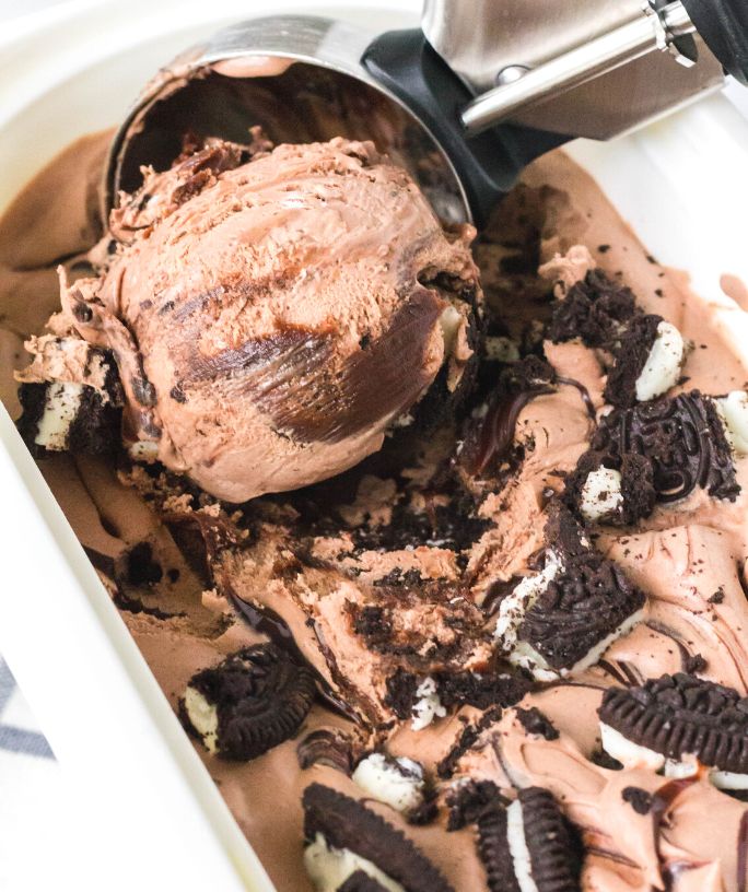 an ice cream scoop rolls a scoop of homemade no-churn Mississippi Mud ice cream