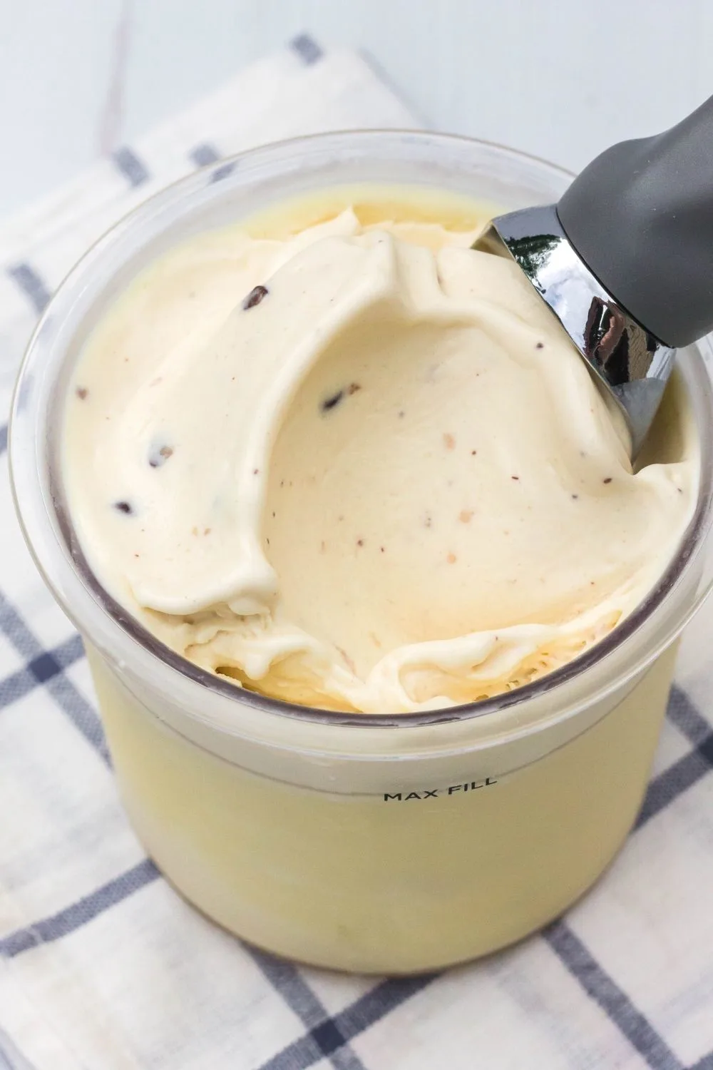 a Ninja Creami pint container filled with cookie dough ice cream. An ice cream scoop is in the pint.