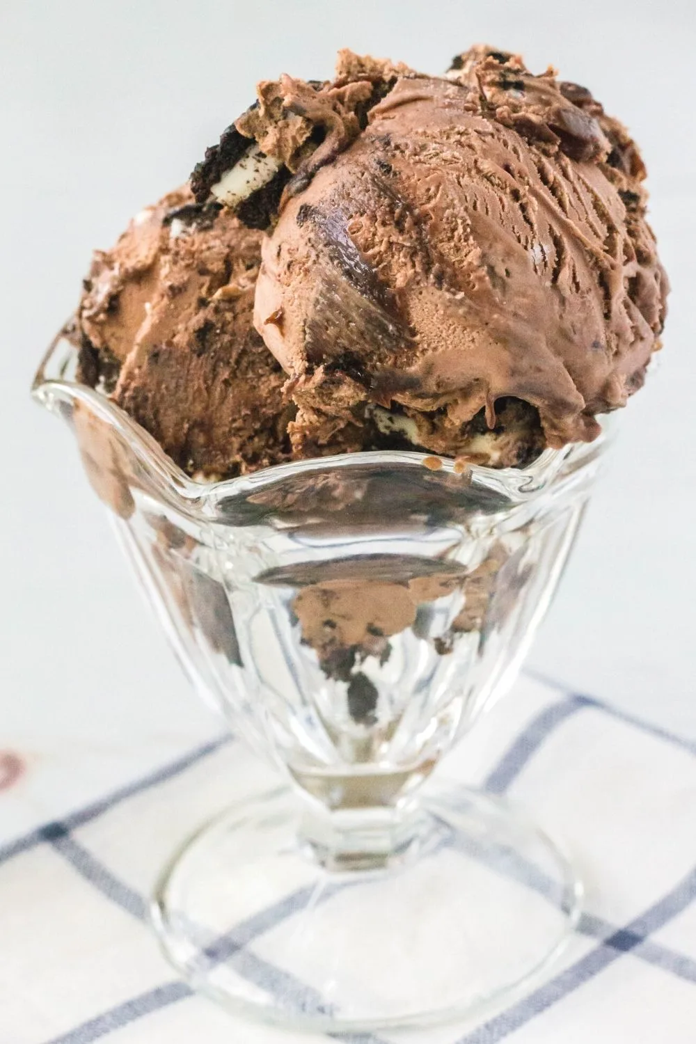 scoops of no-churn mississippi mud ice cream are served in a glass ice cream dish.