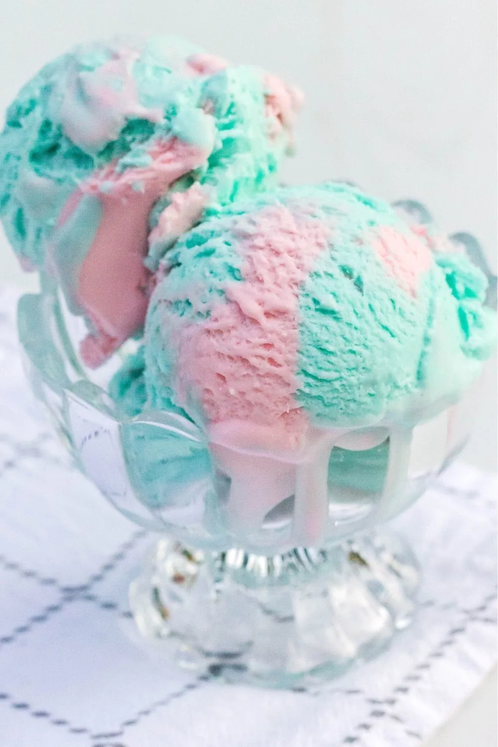 two scoops of no-churn cotton candy ice cream served in a glass dish