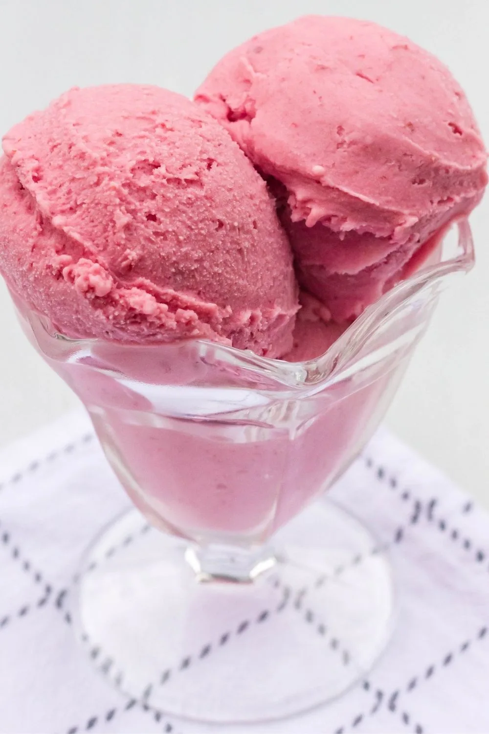 scoops of Ninja Creami cranberry ice cream served in a glass dessert cup