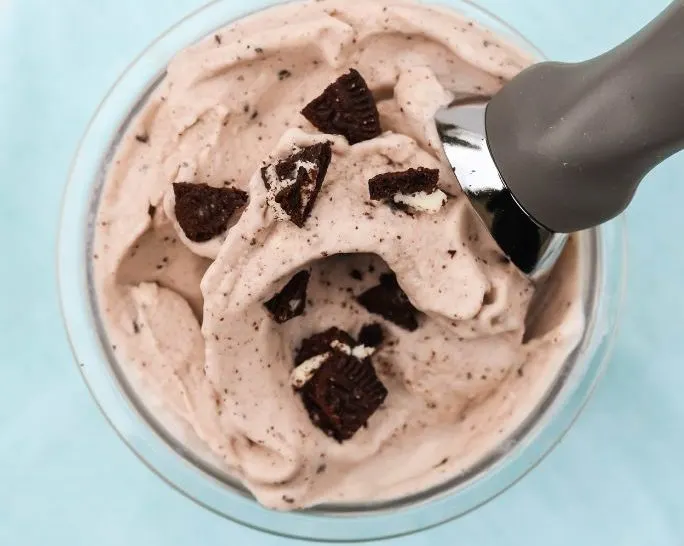 overhead view of Ninja Creami Oreo protein ice cream in a pint container with an ice cream scoop