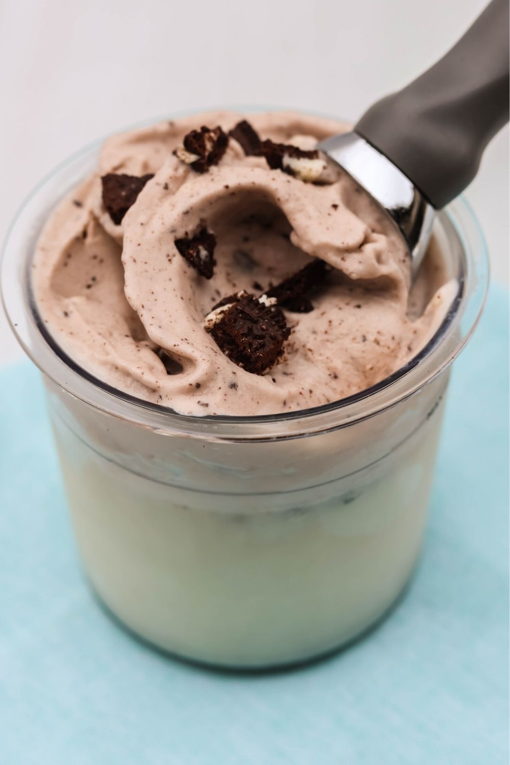Ninja Creami high protein cookies and cream ice cream in a pint container, with an ice cream scoop in it