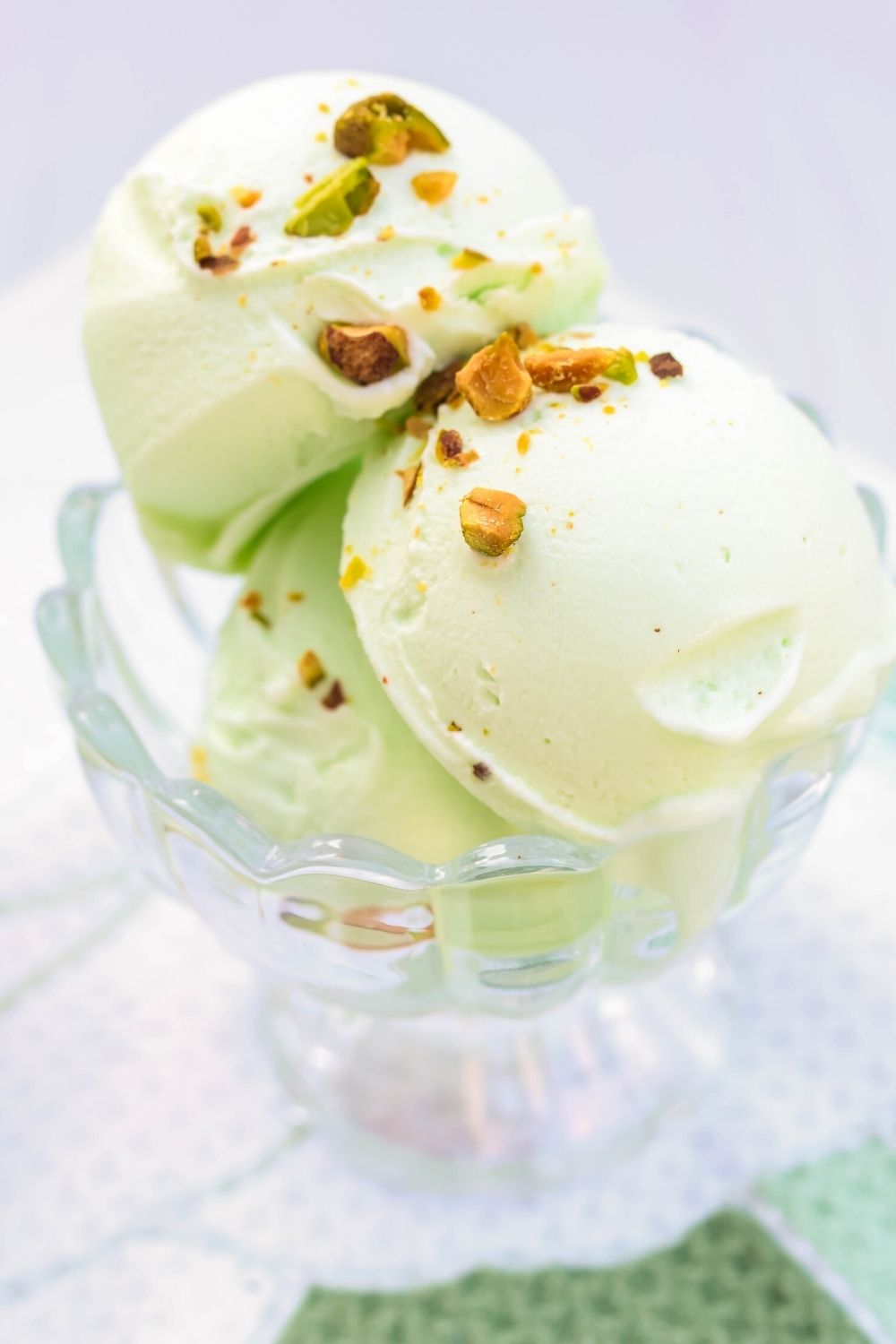 close-up view of scoops of low carb pistachio ice cream made in the Ninja Creami, served in a glass dish.