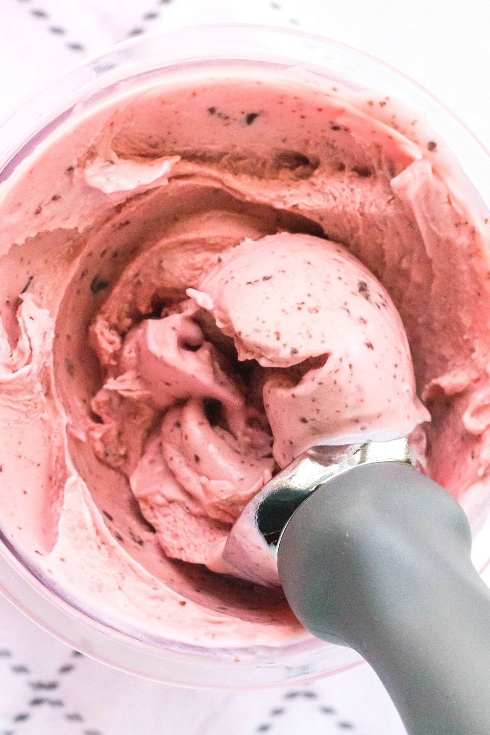 overhead view of a Ninja Creami pint container with chocolate pieces mixed into the ice cream