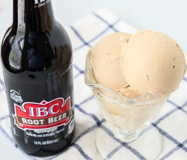 Ninja Creami root beer ice cream served in a dessert cup, with a bottle of root beer next to it.