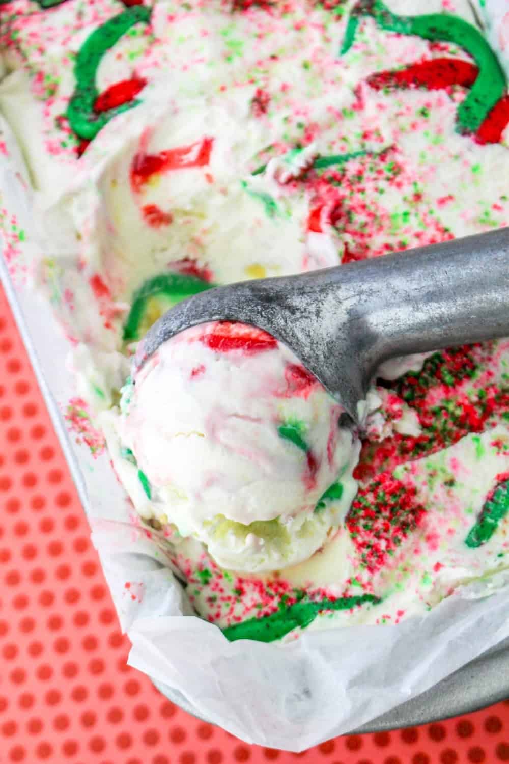 an ice cream scoop is scooping out homemade ice cream made with Christmas cookies.