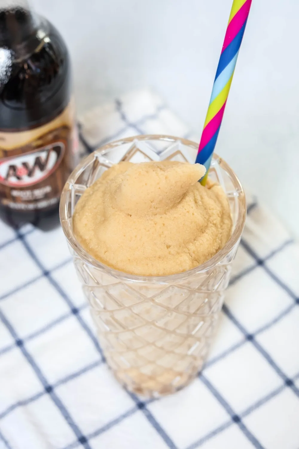 Ninja Slushi made with root beer, served in a glass. A bottle of A&W root beer is next to it.