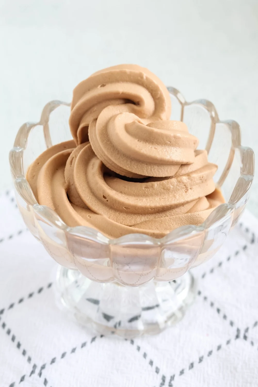 close-up side view of a swirl of soft serve frozen yogurt made in the Ninja Creami Swirl, showing the creamy texture. It's chocolate hazelnut banana flavor.