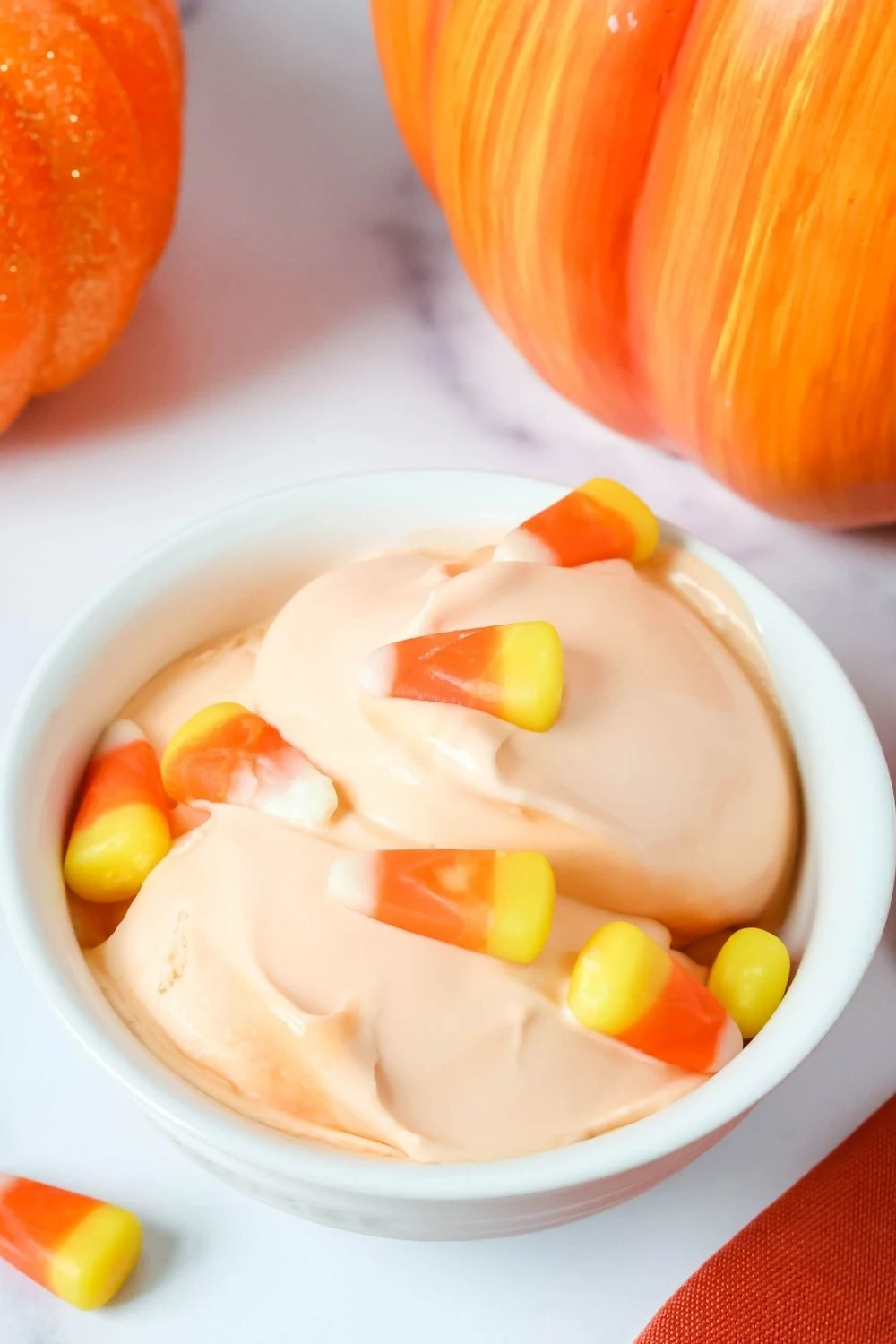 a white bowl of candy corn ice cream garnished with candy corns.