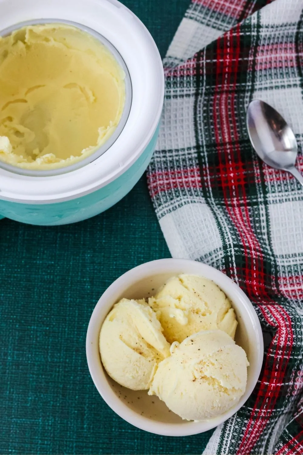 overhead view of a white bowl with scoops of eggnog ice cream in it; the Dash My Mug bowl is in the background.