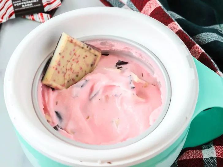 Dash My Mug peppermint bark ice cream served in the mug bowl, garnished with a square of peppermint bark candy.