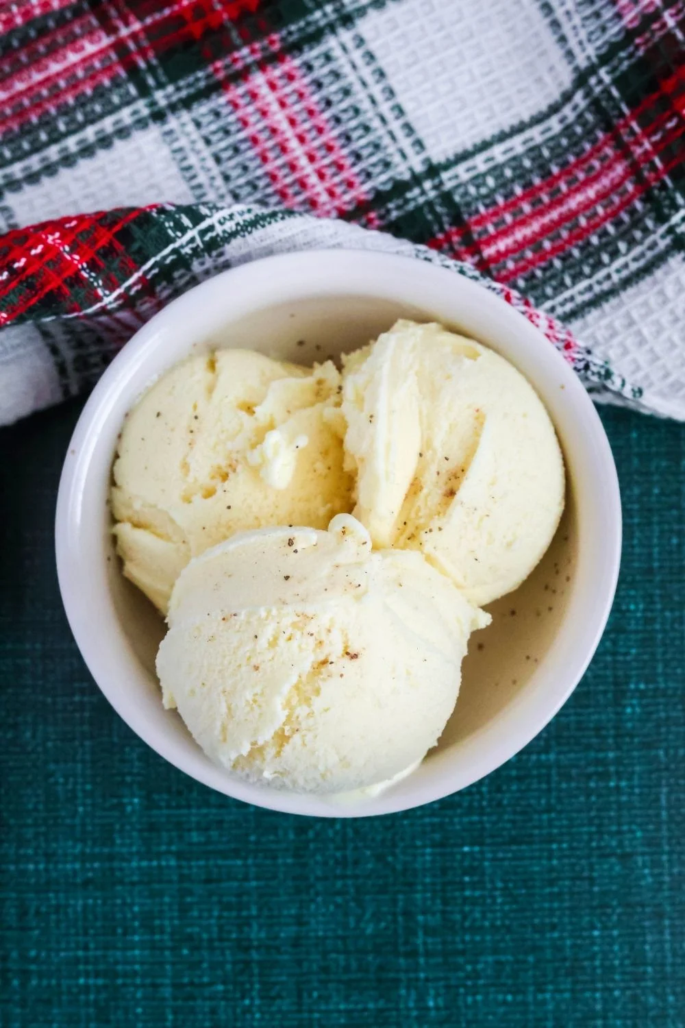 three scoops of small batch eggnog ice cream in a white bowl