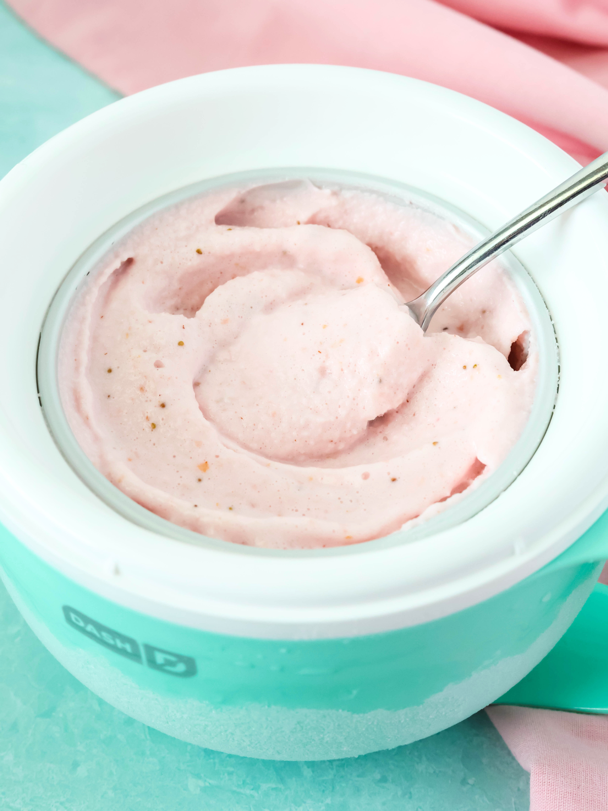 Dash My Mug strawberry frozen yogurt with a spoon removing a bite.