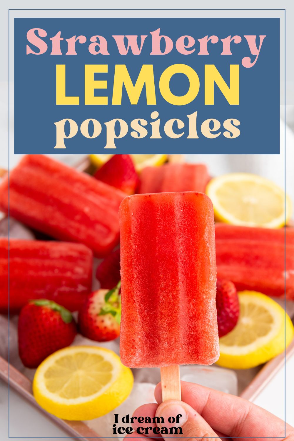 a woman's fingers hold a strawberry lemon popsicle, with more fruit pops in the background.