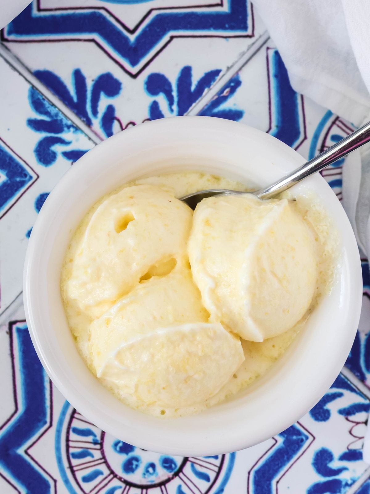 fresh pineapple sorbet served in a white bowl with a spoon.