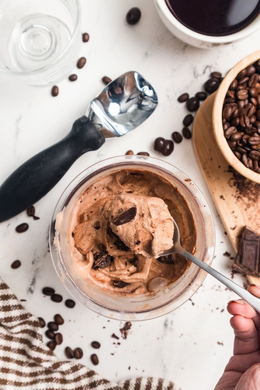 a spoon lifts a bite of Ninja Creami mocha ice cream from a pint container.