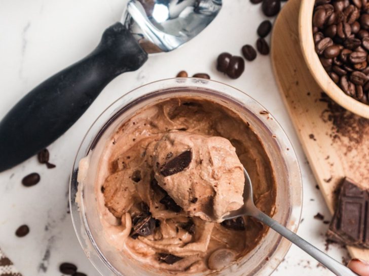 a spoon lifts out a bite of Ninja Creami mocha ice cream from a pint container.
