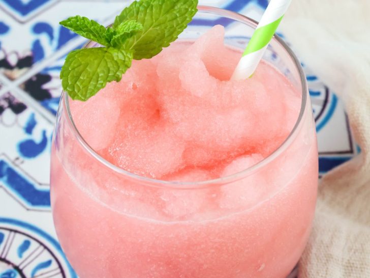 Ninja Slushi Watermelon Limeade Slush served in a glass with a straw and sprig of mint.