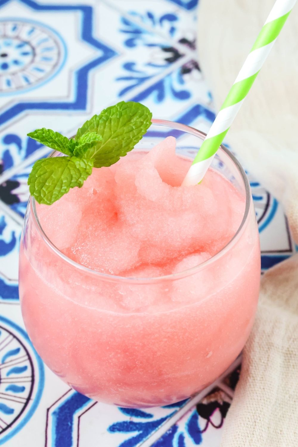 Ninja Slushi watermelon lime slush served in a glass with a straw and sprig of mint.