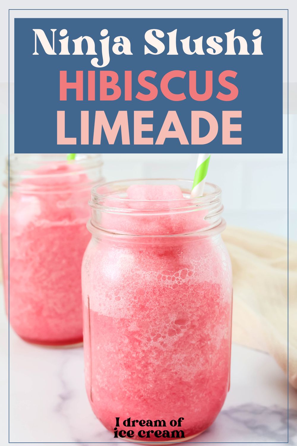 two Mason jars of Ninja Slushi hibiscus limeade served with green stripe straws.