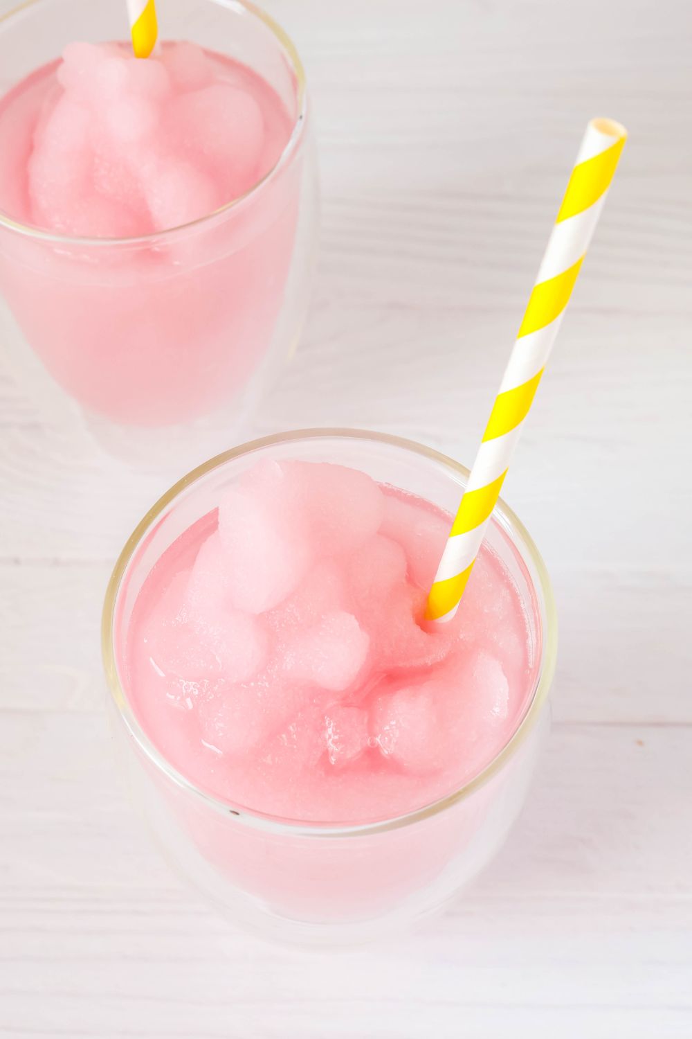 Ninja Slushi Disney violet lemonade served in two glasses with yellow and white straws.