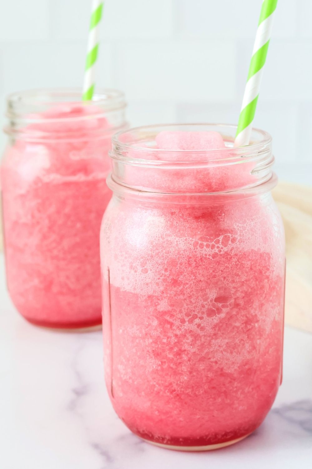 Two Mason jar glasses serving slushi made with hibiscus tea.